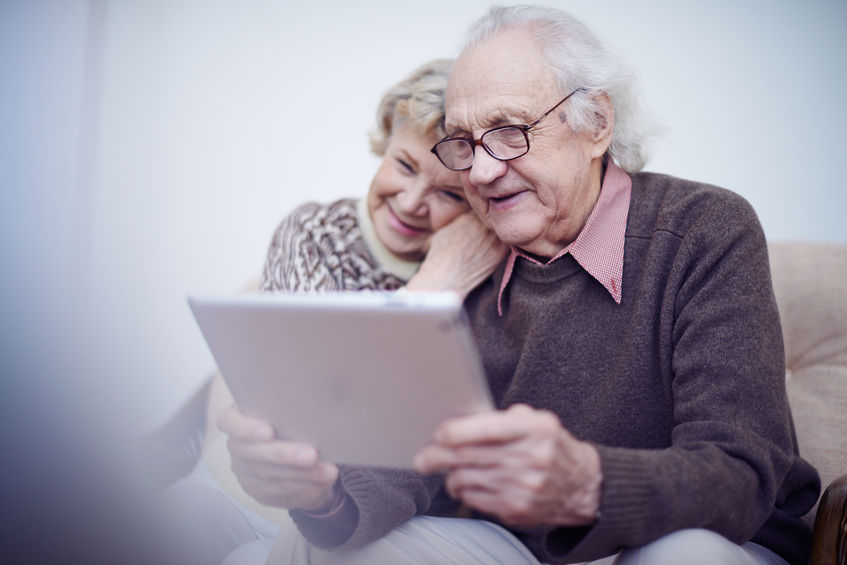 elderly husband and wife using touchpad